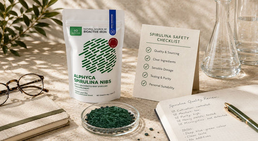 Spirulina quality review with a checklist, notebook, and blue-green spirulina nibs, illustrating safe and informed supplement choices.