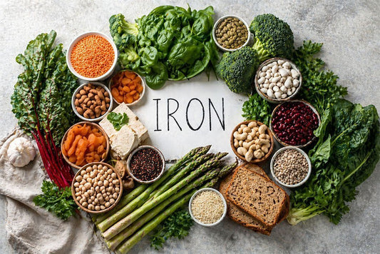 Top-down view of iron-rich plant foods arranged alongside vitamin C foods to illustrate absorption pairing